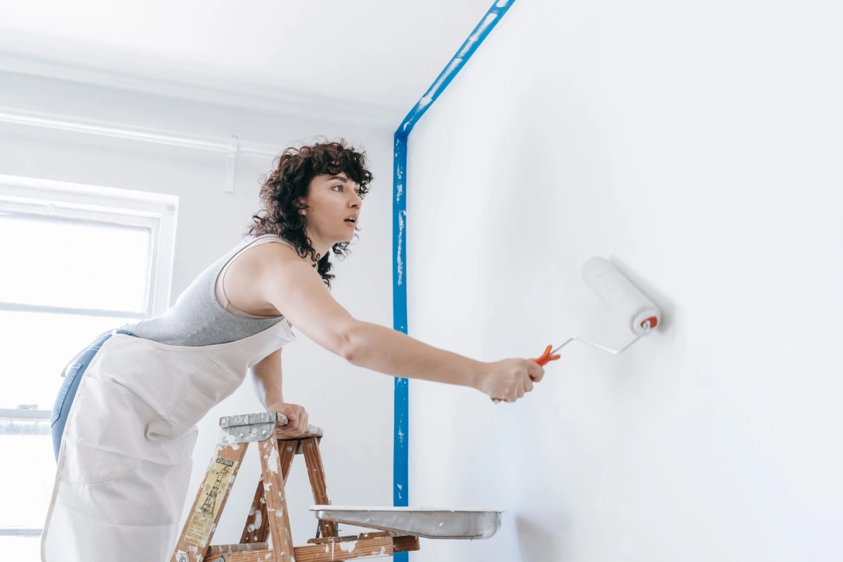 Application au rouleau d'une peinture claire sur un mur intérieur préparé